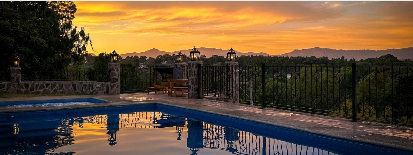 Alberca con vista a la sierra durante el atardecer