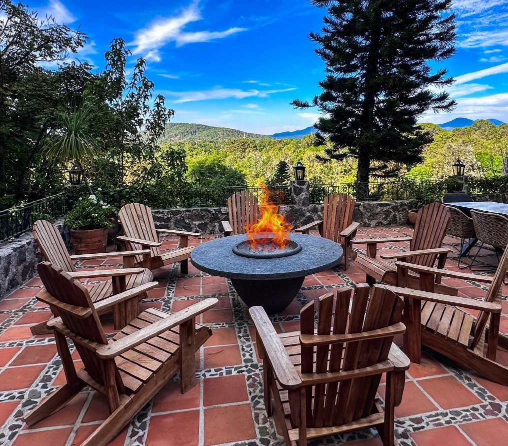 Terraza con fogata, sillas de madera y vista al bosque