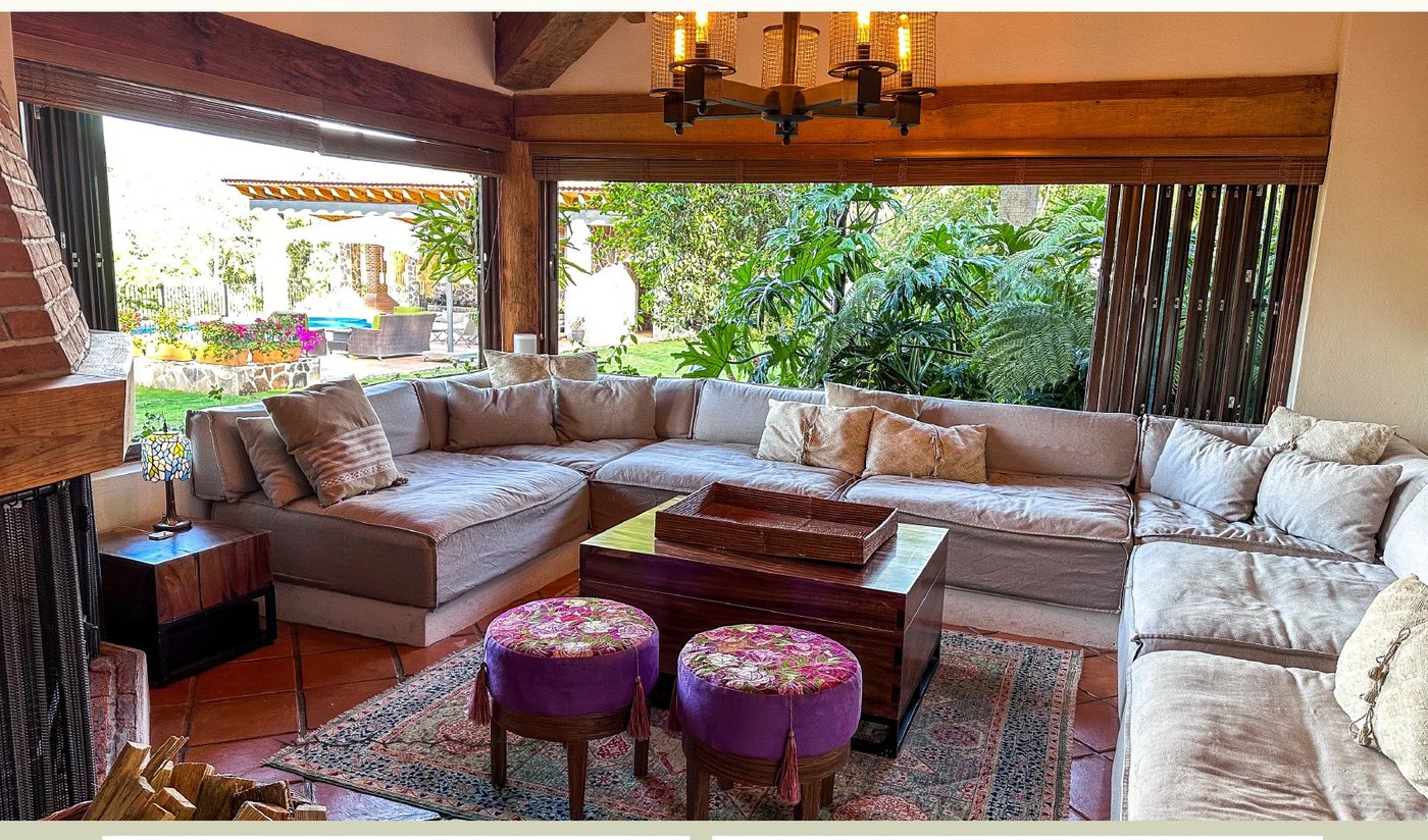 Sala de estar abierta al jardín con grandes ventanales