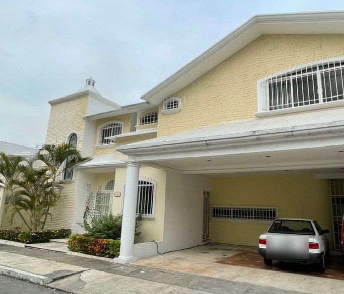 Fachada de casa de dos niveles con cochera techada
