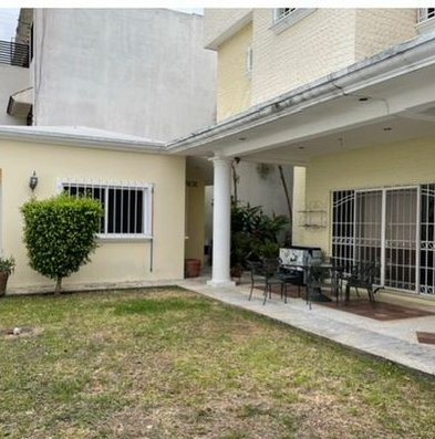Jardín con terraza techada y área de comedor exterior