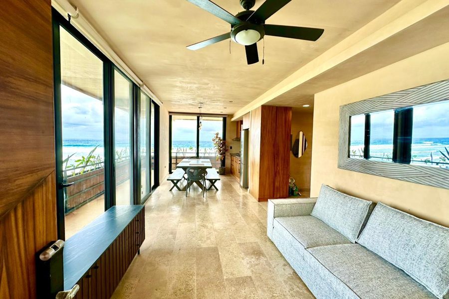 Sala amueblada con ventanales y vista al mar