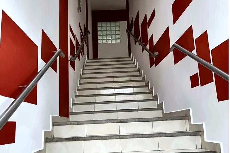 Escalera interior con patrón geométrico rojo sobre blanco