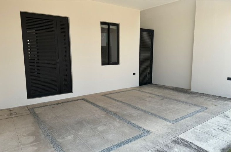 Área de estar abierta con muro de cristal al patio